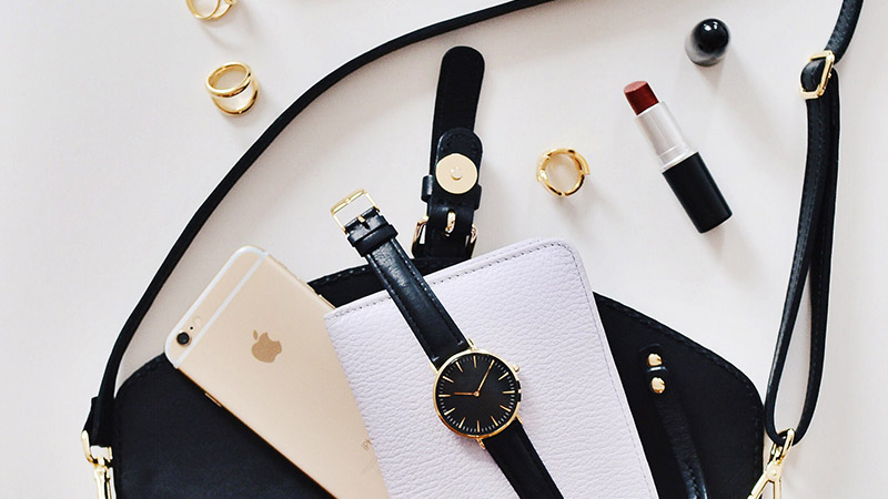 brand named phone, watch and other jewelry on table