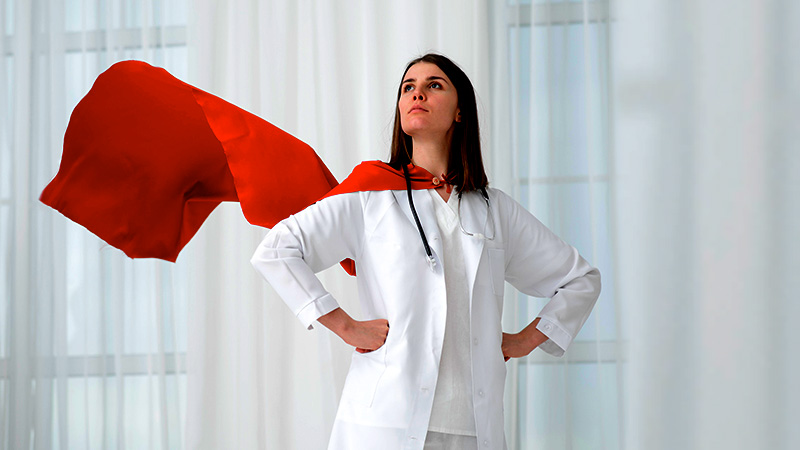 Female doctor standing in a hero pose with a cape